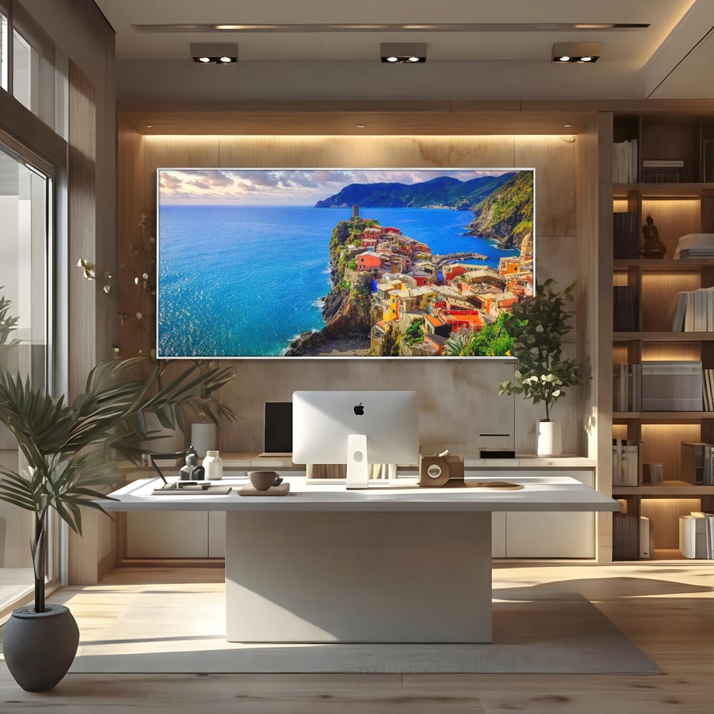 Tablou canvas cu peisaj costier italian cu sat colorat pe stanca, in rama de aluminiu argintiu, pe perete intr-un birou